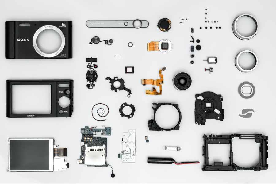 The individuals parts of a camera layout out on a flat surface 